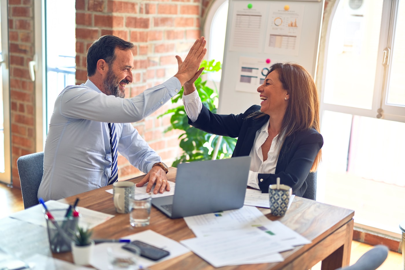 Consultora e cliente comemorando resultado sobre planilhas